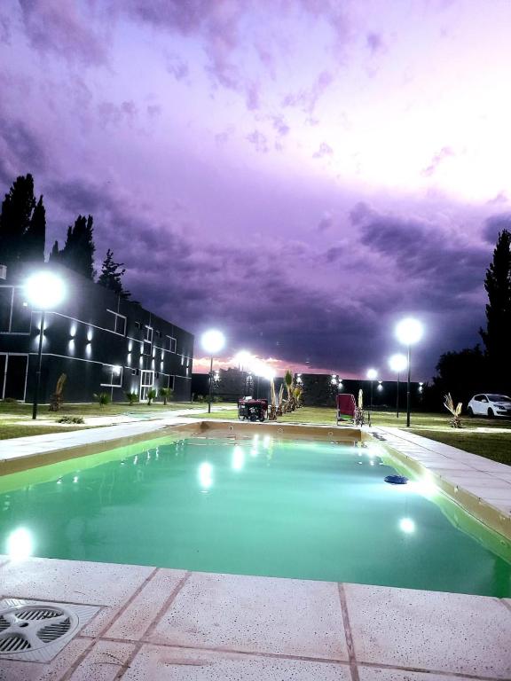 an empty swimming pool at night with a cloudy sky at El Atardecer Complejo Turístico in San Rafael