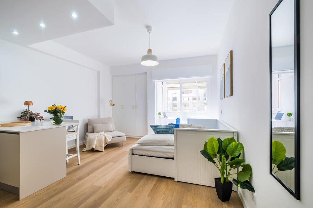 Dieses weiße Apartment verfügt über eine Küche und ein Wohnzimmer. in der Unterkunft Beach Apartment by Portugal Portfolio in Paço de Arcos