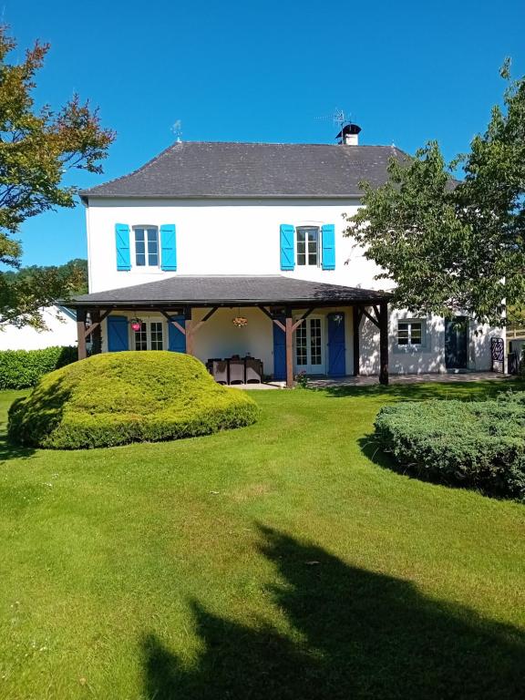 a white house with blue shutters and a yard at Bel appartement de plein pied avec jardin privé in Moncayolle-Larrory-Mendibieu