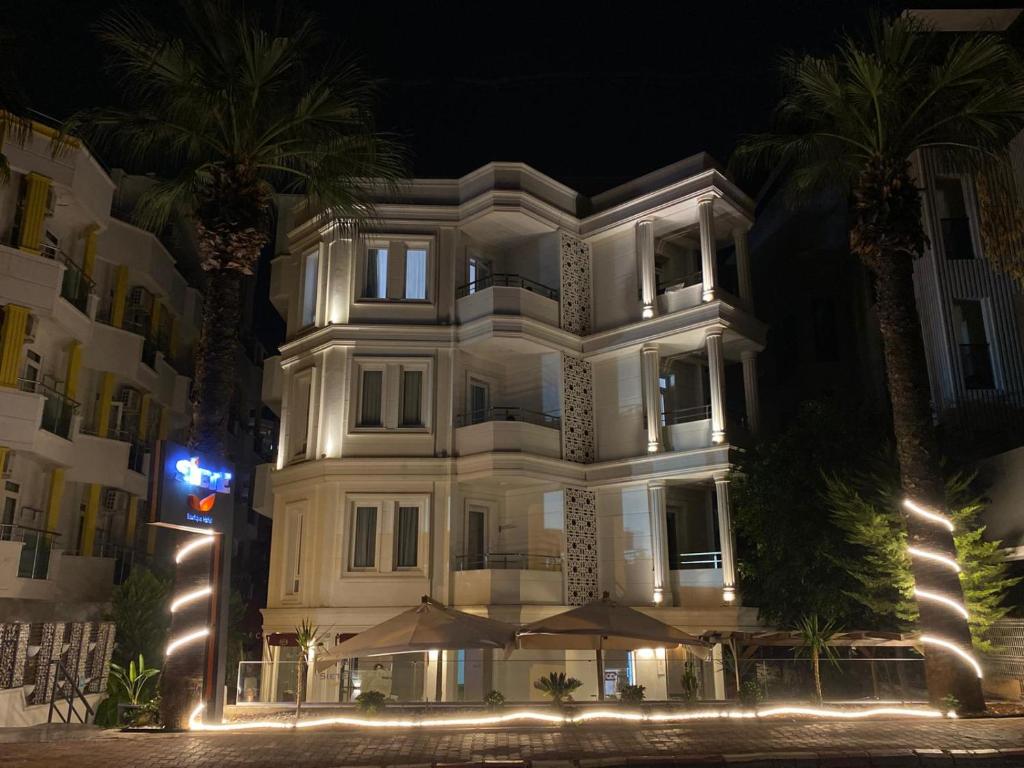 Un gran edificio blanco con palmeras delante. en Siete Hotel, en Antalya