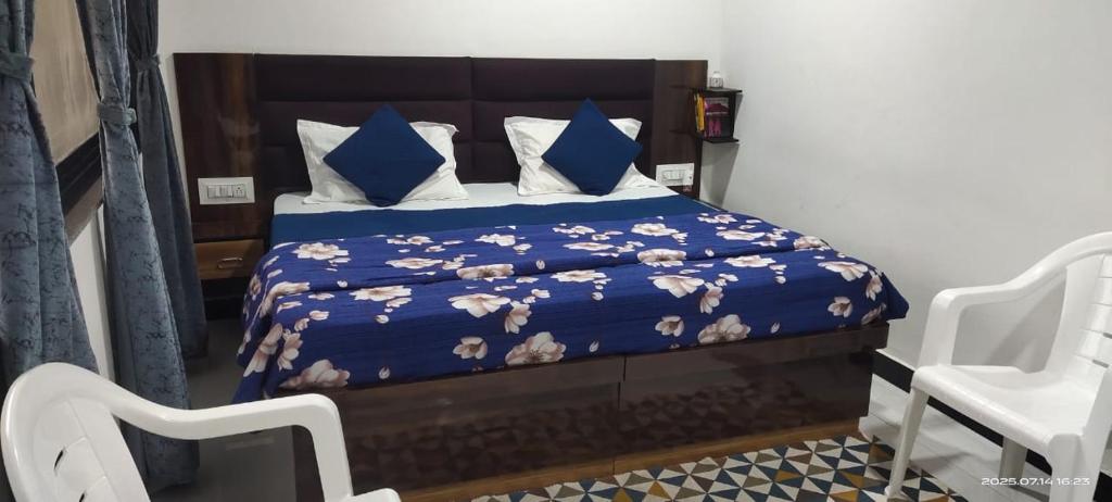 Un dormitorio con una cama con sábanas azules y almohadas azules. en Amri's Villa, en Mount Abu