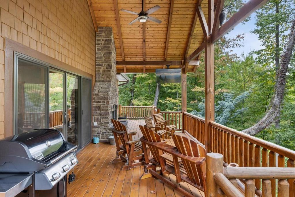 eine Veranda mit Stühlen und einem Grill auf einem Haus in der Unterkunft Winter Deal! 2 Master Suites, Fireplace, Hot tub in Sevierville