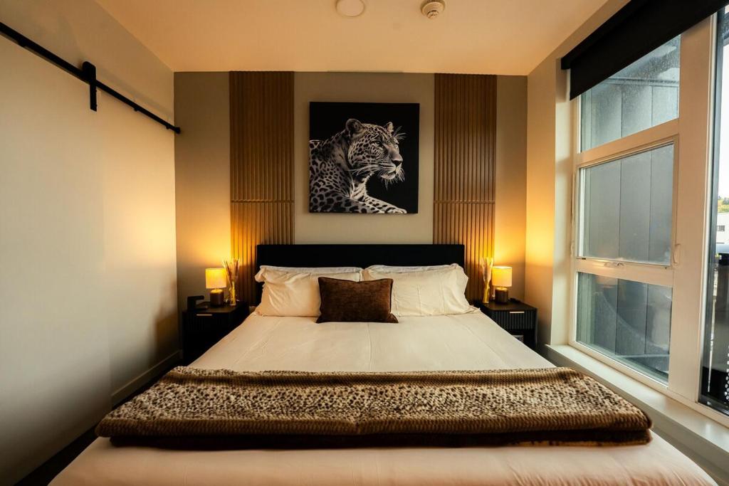 a bedroom with a bed with a tiger picture on the wall at Heart of Downtown Apt with City View, Walkable to HotSpots in Spokane