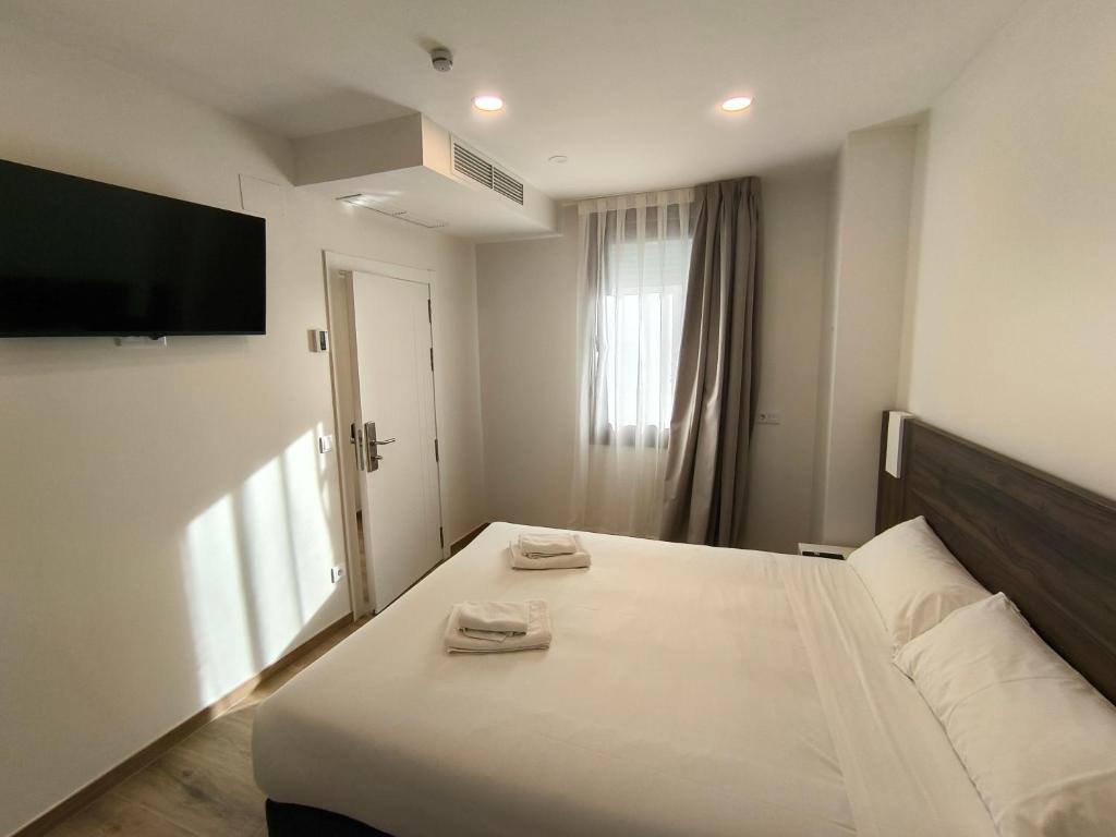 a bedroom with a bed and a flat screen tv at HeyWelcome Valladolid Centro in Valladolid