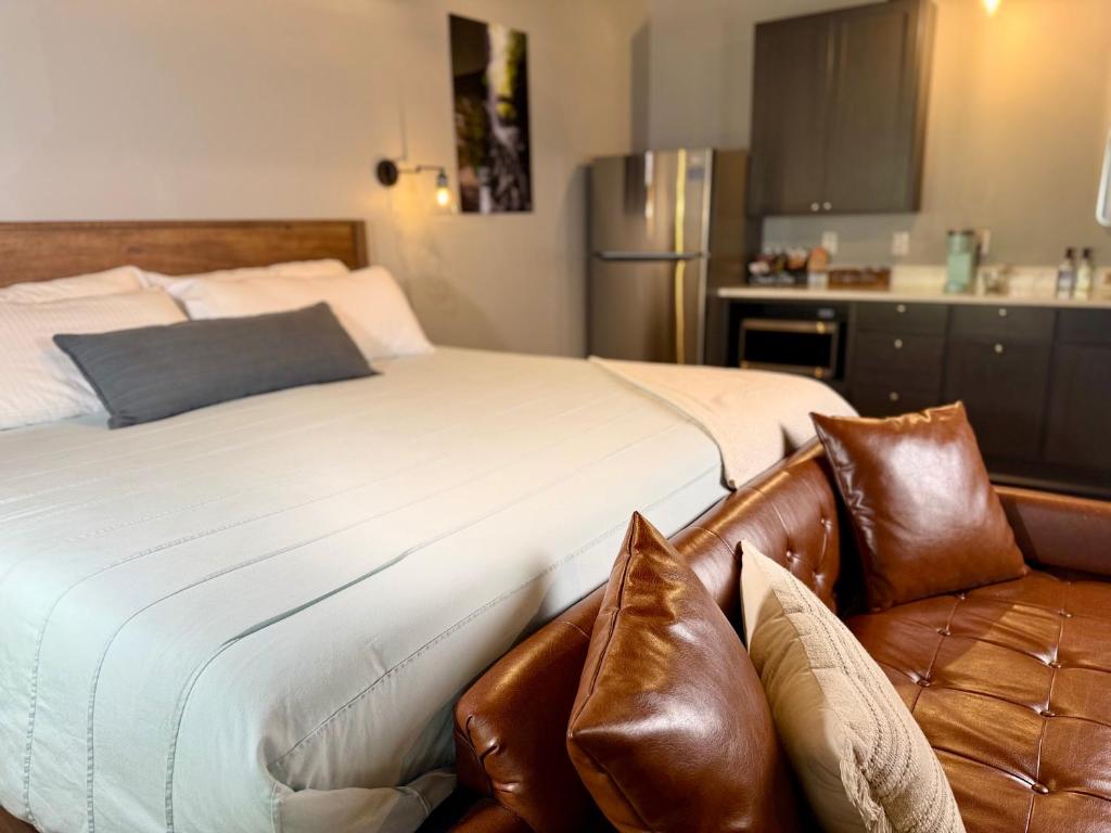 a bedroom with a large bed with brown leather seats at The Benjamin Hotel in Watkins Glen