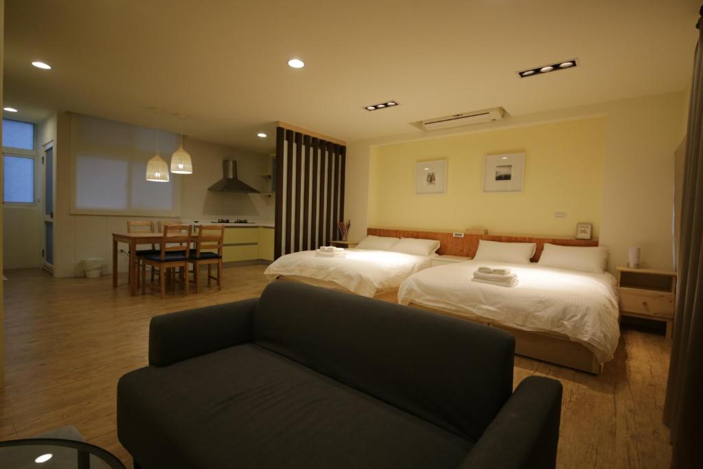 ein Hotelzimmer mit 2 Betten und einem Sofa in der Unterkunft YO HOO FARM 16 HOUSE in Kaohsiung