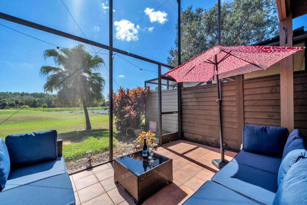 een patio met twee blauwe banken en een parasol bij Tee Time Tranquility in Wesley Chapel