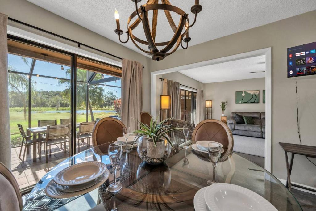 a dining room with a glass table and chairs at Tee Time Tranquility in Zephyrhills