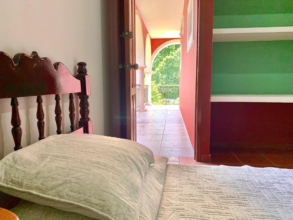 a bedroom with a bed and an open door at Habitacion chica con piscina in Mérida