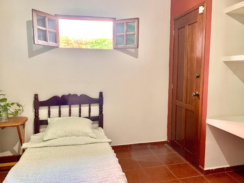 a bedroom with a bed and a window at Habitacion chica con piscina in Mérida