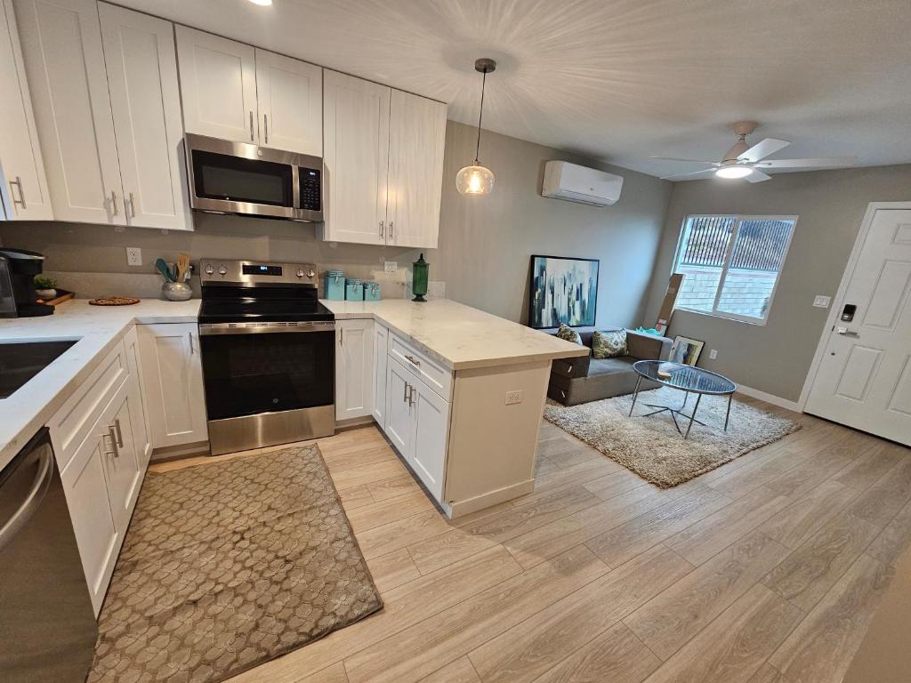 a kitchen with white cabinets and a stove top oven at Beautiful new construction 1br with full size appliances centrally located in La Mesa
