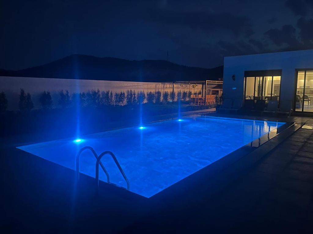 una grande piscina di notte con luci blu di Houseselect a Nador
