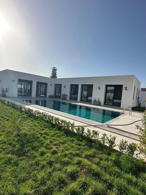 a building with a swimming pool in front of it at Houseselect in Nador