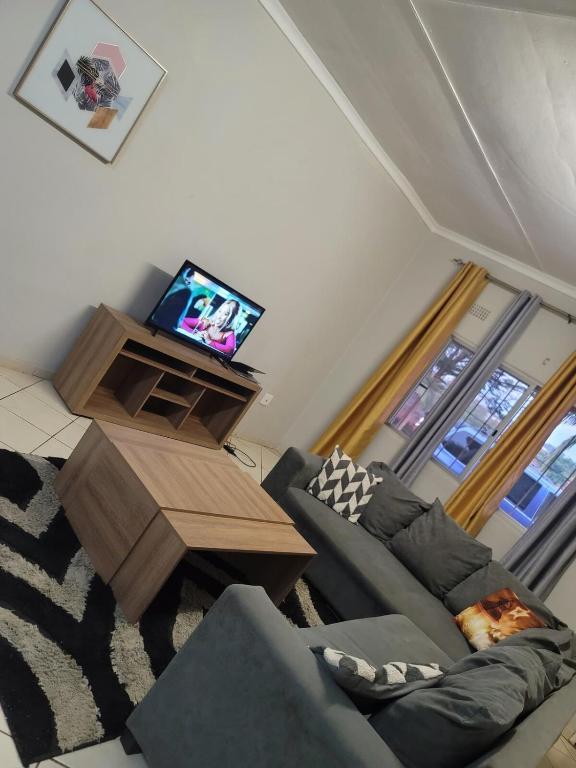 a living room with a couch and a television at Nestville apartment in Solwezi