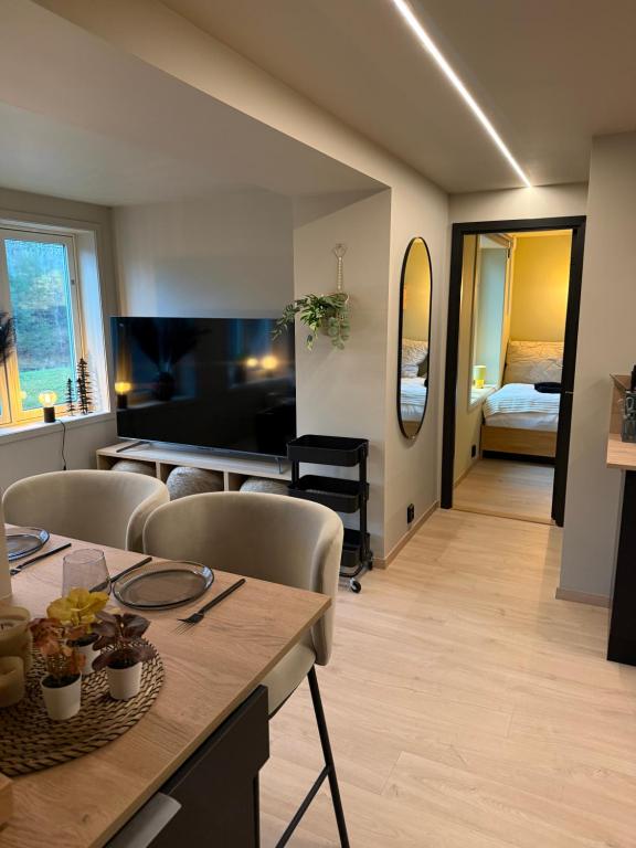 a living room with a table and chairs and a bedroom at Notodden Luxe two-bedroom Apartment in Notodden
