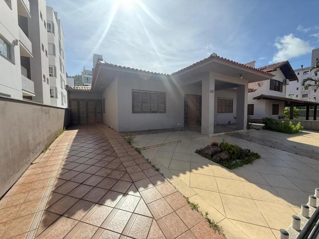 una grande casa bianca con il sole nel cielo di Cód 16 - Casa a pouco a metros do mar a Governador Celso Ramos