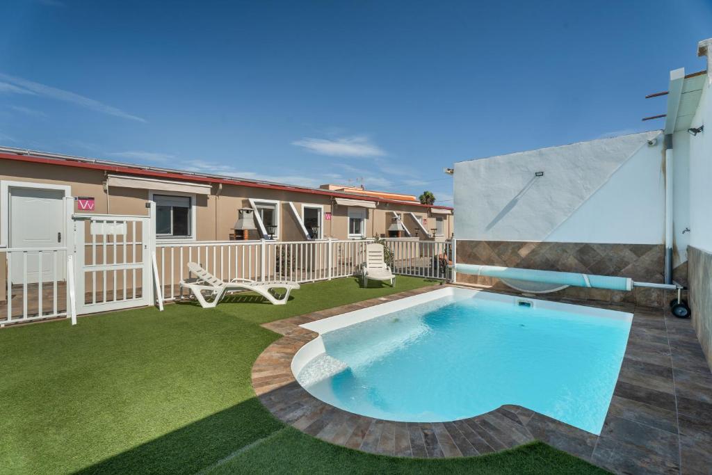 un patio trasero con piscina y tobogán en 1 Apartamentos Omanai Tenerife Sur, en Las Galletas