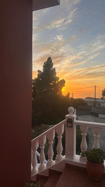a view of a sunset from a white balcony at La Viñita in El Paso