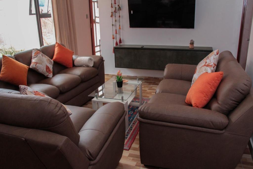 a living room with two couches and a television at Valle Sagrado Mágico in Urubamba