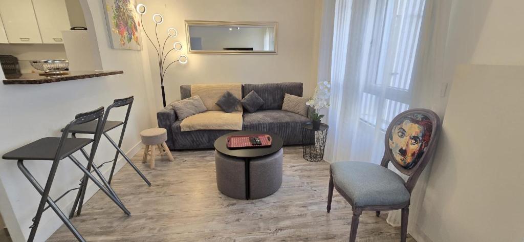 ein Wohnzimmer mit einer Couch und einem Tisch und Stühlen in der Unterkunft Le Cocon madonna T2 400 m du sanctuaire de Lourdes in Lourdes