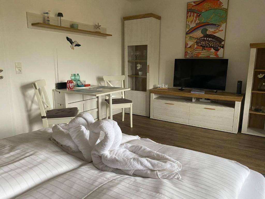 a room with a bed with a table and a television at PEMATRA FeWo Kleine Brise in Travemünde