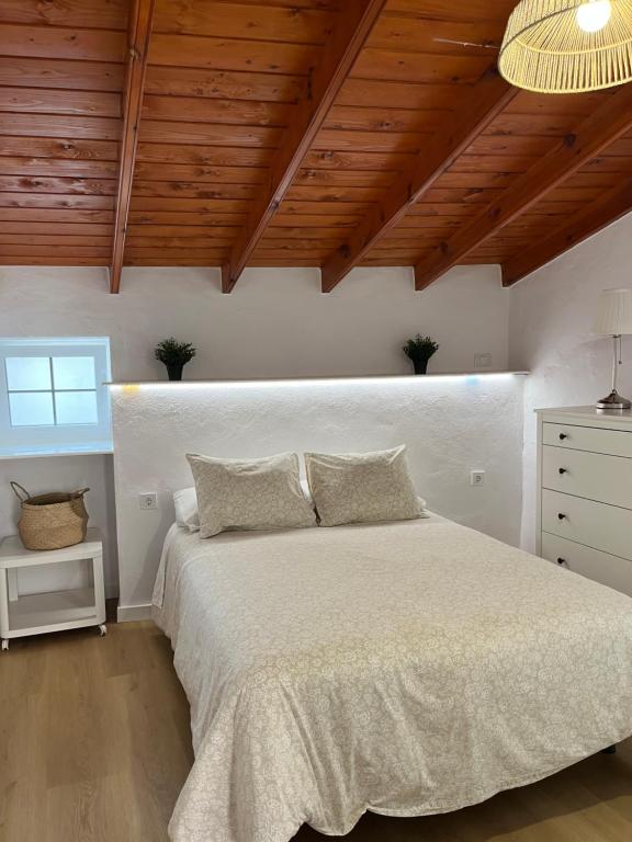 a bedroom with a white bed and a wooden ceiling at Moya senderos, naturaleza y mar 2 in Moya