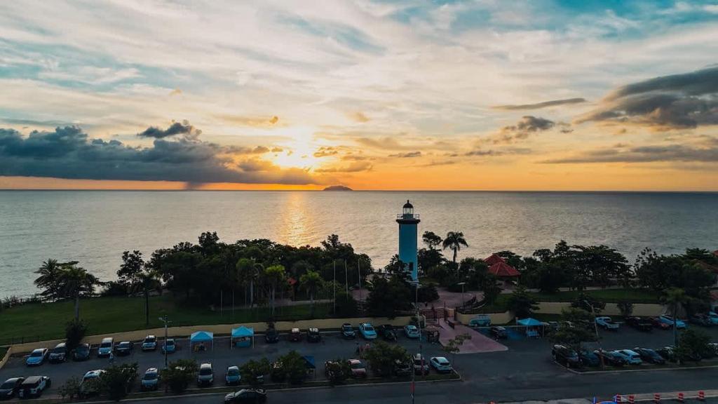 a sunset over a parking lot with a lighthouse at Isla Apartment in Ocean Club Rincon in Corcega