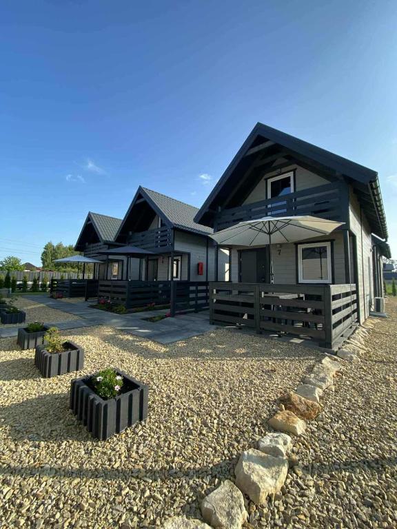 a house with an umbrella on a gravel driveway at Sister's House Zator in Zator