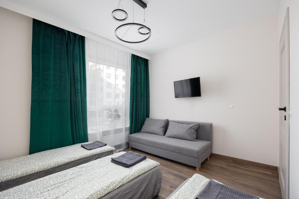 a living room with two beds and a couch at Pokoje Warszawski Świt in Warsaw