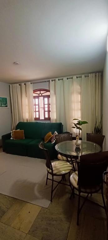 a living room with a green couch and a table at Apartamento - Centro Itapuã - 1Q in Vila Velha