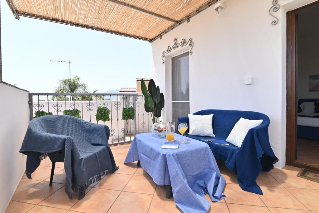 a living room with a blue table and chairs at IzzHome Sea Style Room in Pula