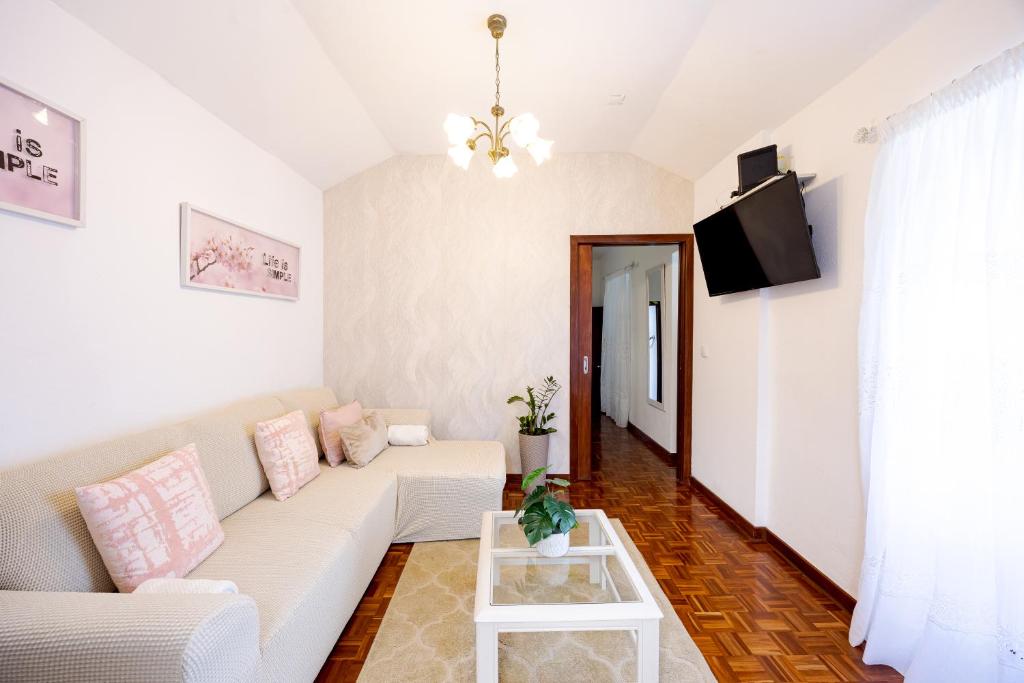 a living room with a white couch and a tv at Peaceful Panorama by YOUR KEY MADEIRA in Porto Moniz