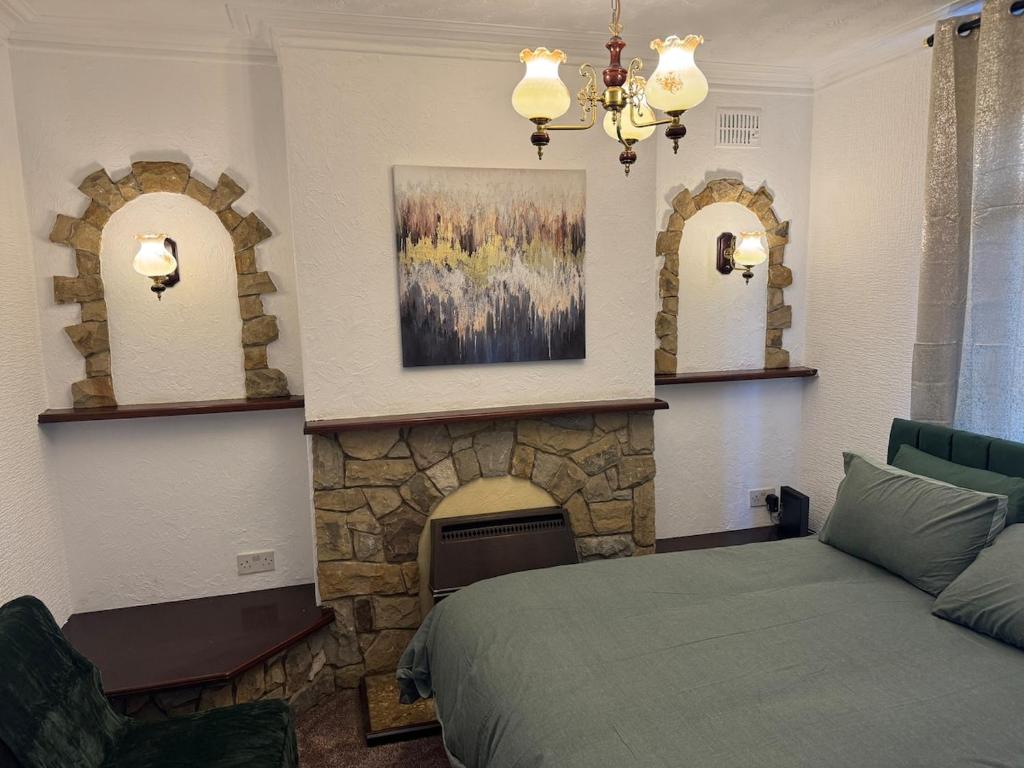 ein Schlafzimmer mit einem Kamin und einem Bett in einem Zimmer in der Unterkunft Modern 3Bed Doncaster Home with Vintage Charm in Balby