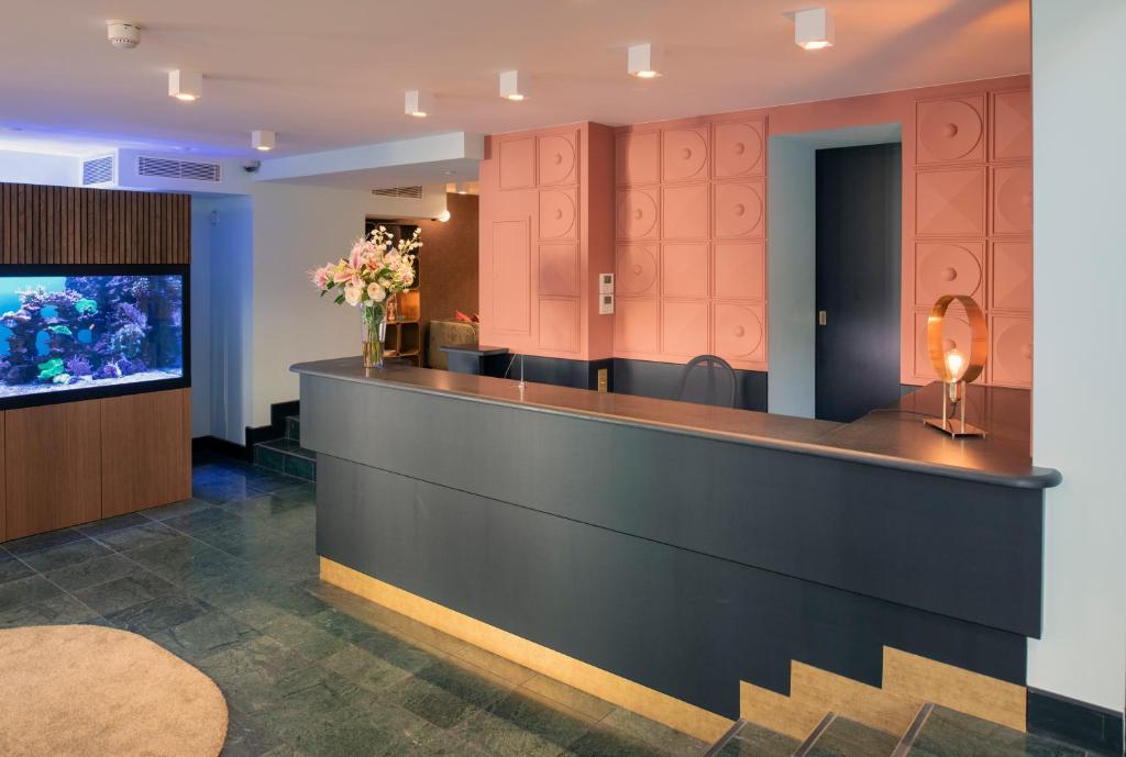 a lobby with a waiting area with an aquarium at Hôtel Pax in Geneva