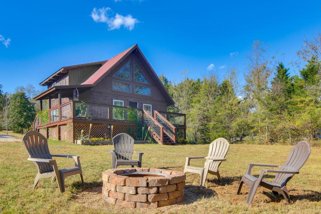 four chairs around a fire pit in front of a house at Hike and Unwind, Peaceful Wooded Retreat in Newport in Newport
