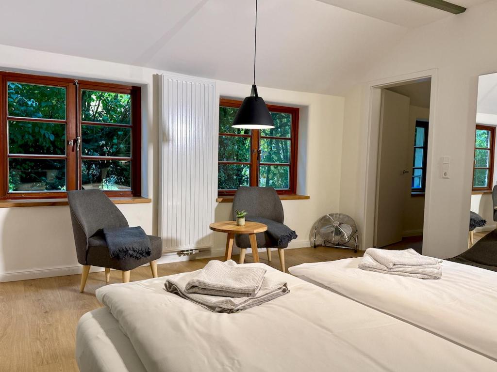 two beds in a room with two chairs and a table at Das Anni's in Wangerland