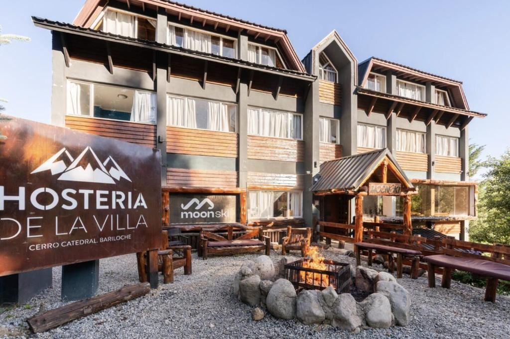 eine Hütte mit einer Feuerstelle vor einem Gebäude in der Unterkunft Hosteria de la Villa - Moonski in San Carlos de Bariloche