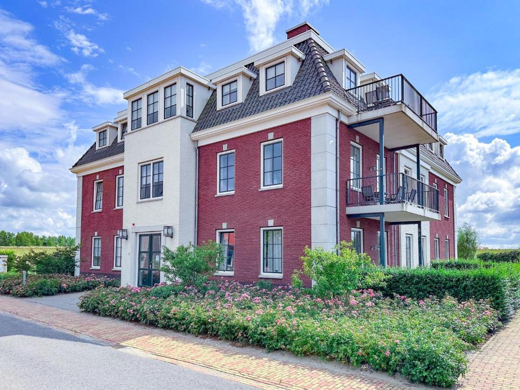 a large red and white building with a balcony at SeaLuxe Suite 27i in Colijnsplaat