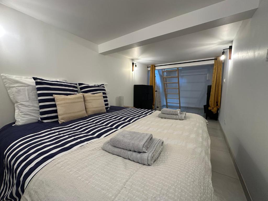 a bedroom with a large bed with towels on it at Chez Camille & Emma - Loft Climatisé in Rochefort