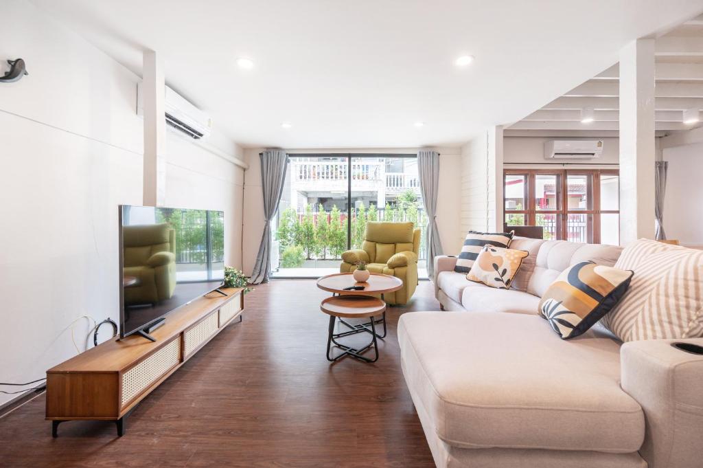 a living room with a couch and a tv at The Mellow at Ekkamai in Bangkok