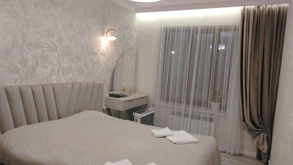 een kleine slaapkamer met een bed en een raam bij Voyage in Karakol