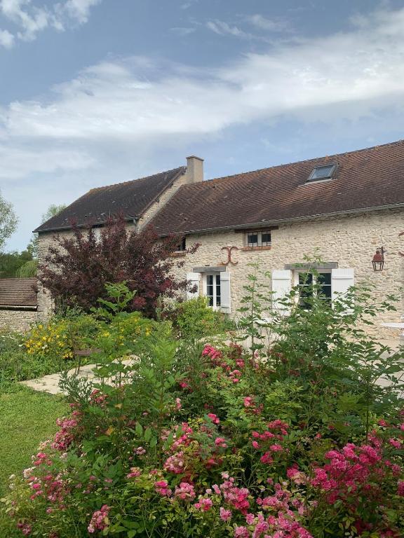 ein Steinhaus mit Blumen davor in der Unterkunft La ferme de Jose in Guainville
