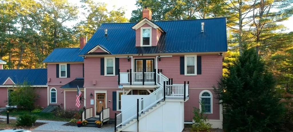 a pink house with a blue roof at TuckAway Suites at East Branch in Intervale