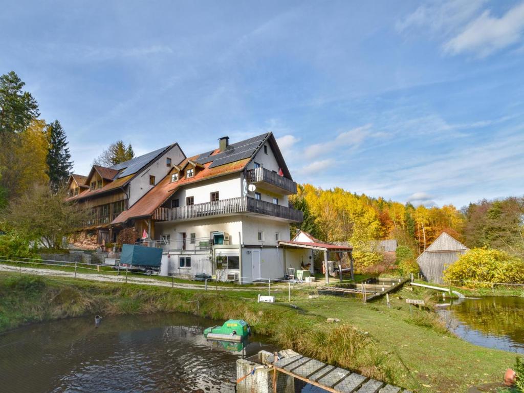 a house next to a river with a boat in the water at Weiherblasch I in Dietersdorf