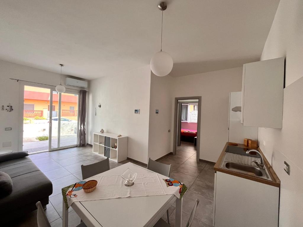 Una sala de estar con una mesa y una cocina. en Beyond Stay - Sardinian Living Experience, en Cagliari