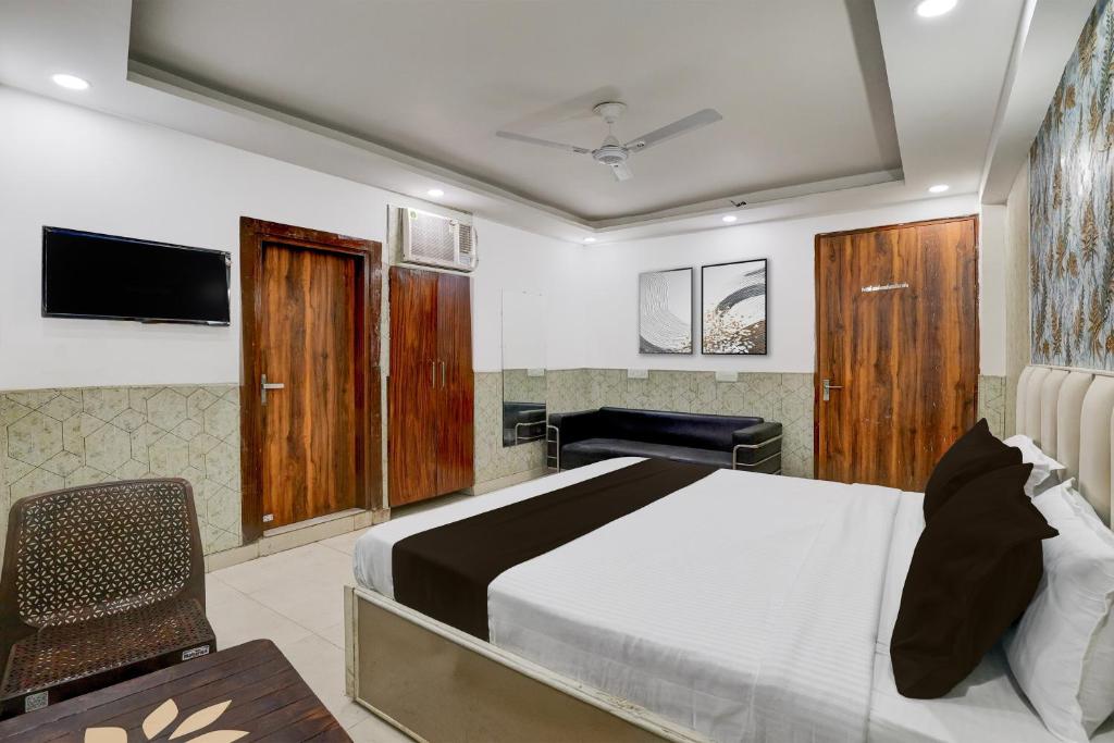 a bedroom with a bed and a desk and a television at Hotel O Akki Residency in Indirapuram