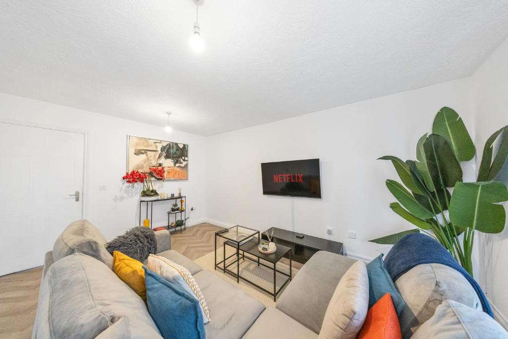 a living room with a couch and a tv at Cozy Two Bedroom House with Driveway Parking & Garden in Chatham