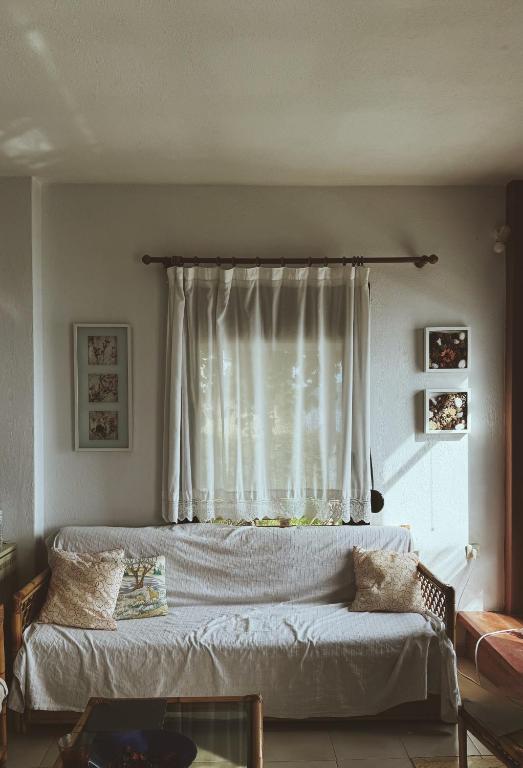a bedroom with a bed and a window with curtains at Athos Cape Traditional House in Pyrgadikia