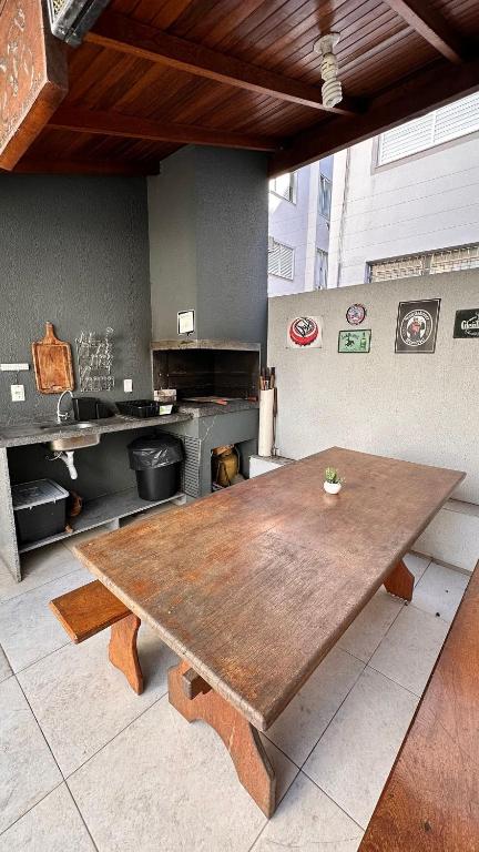 a large wooden table in a large kitchen at Com churrasqueira em Canasvieiras in Florianópolis