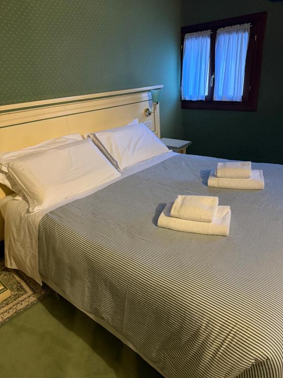 a bedroom with a bed with two towels on it at Locanda Ruga Rialto in Venice